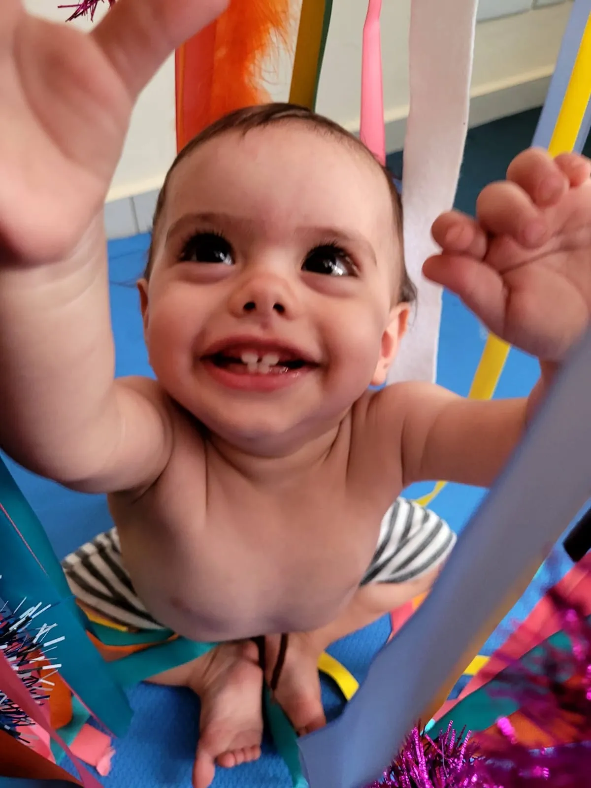 Bebê sorrindo durante atividade de estimulação