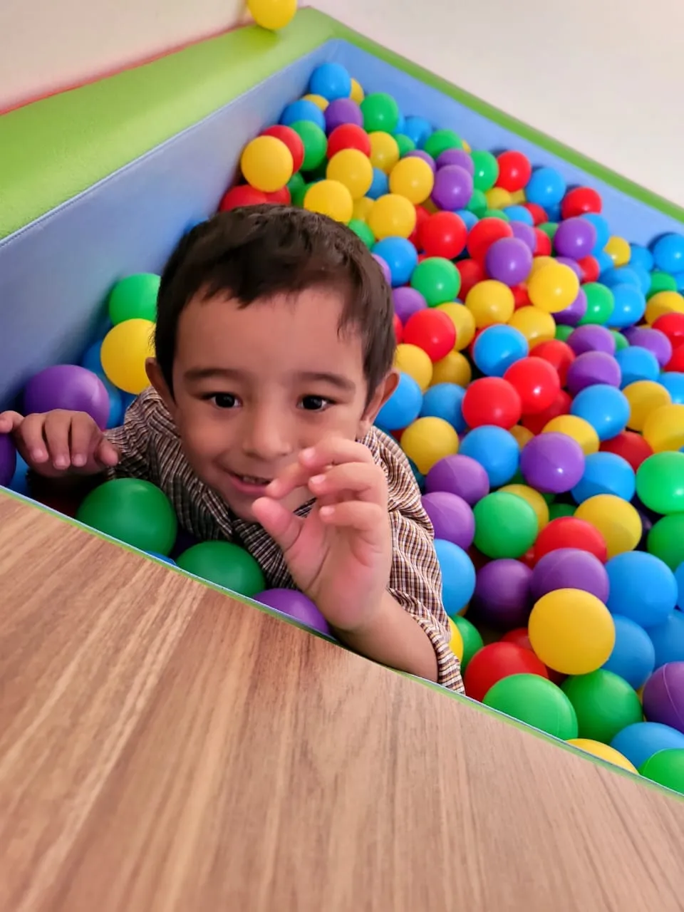 Criança sorrindo dentro da piscina de bolinhas