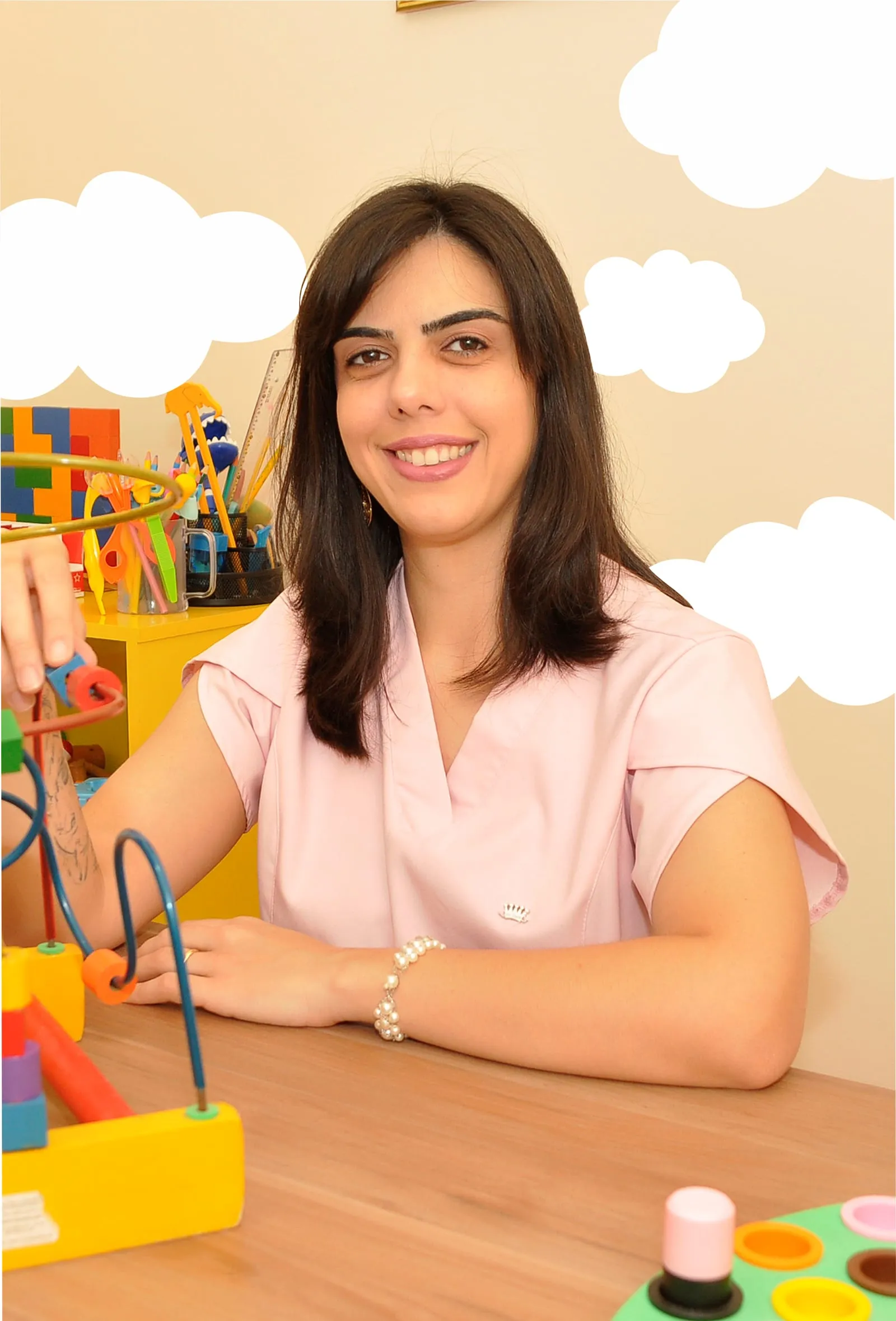 Rebeca Franz sorrindo na sala de atendimento, cercada de brinquedos